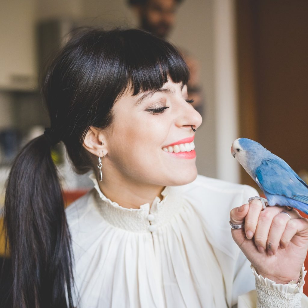 Smiling woman holding bird