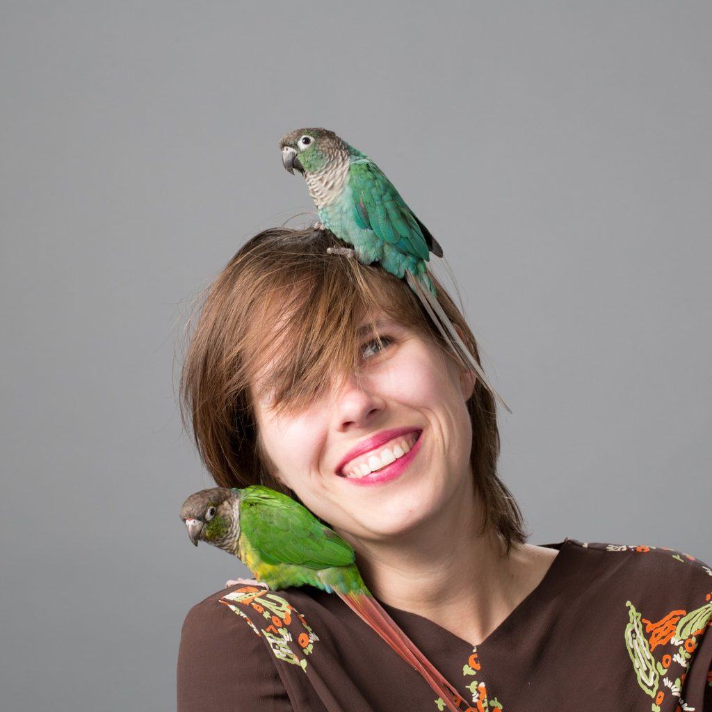 Woman with bird on head and shoulder