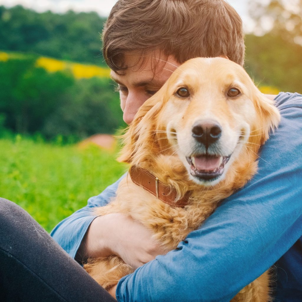 Man hugging golden retriever