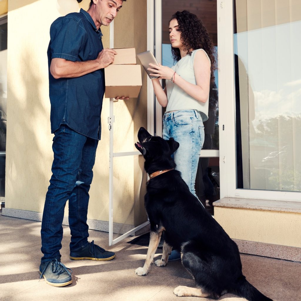 Man and woman with mail with dog watching
