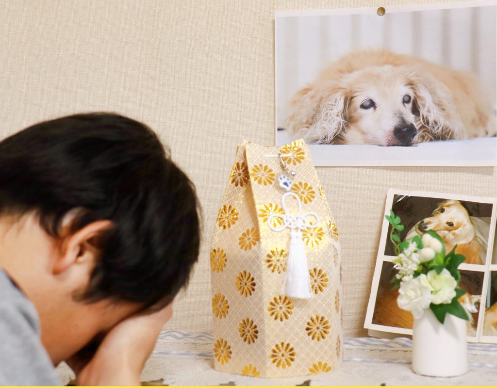 Man crying at pet memorial.