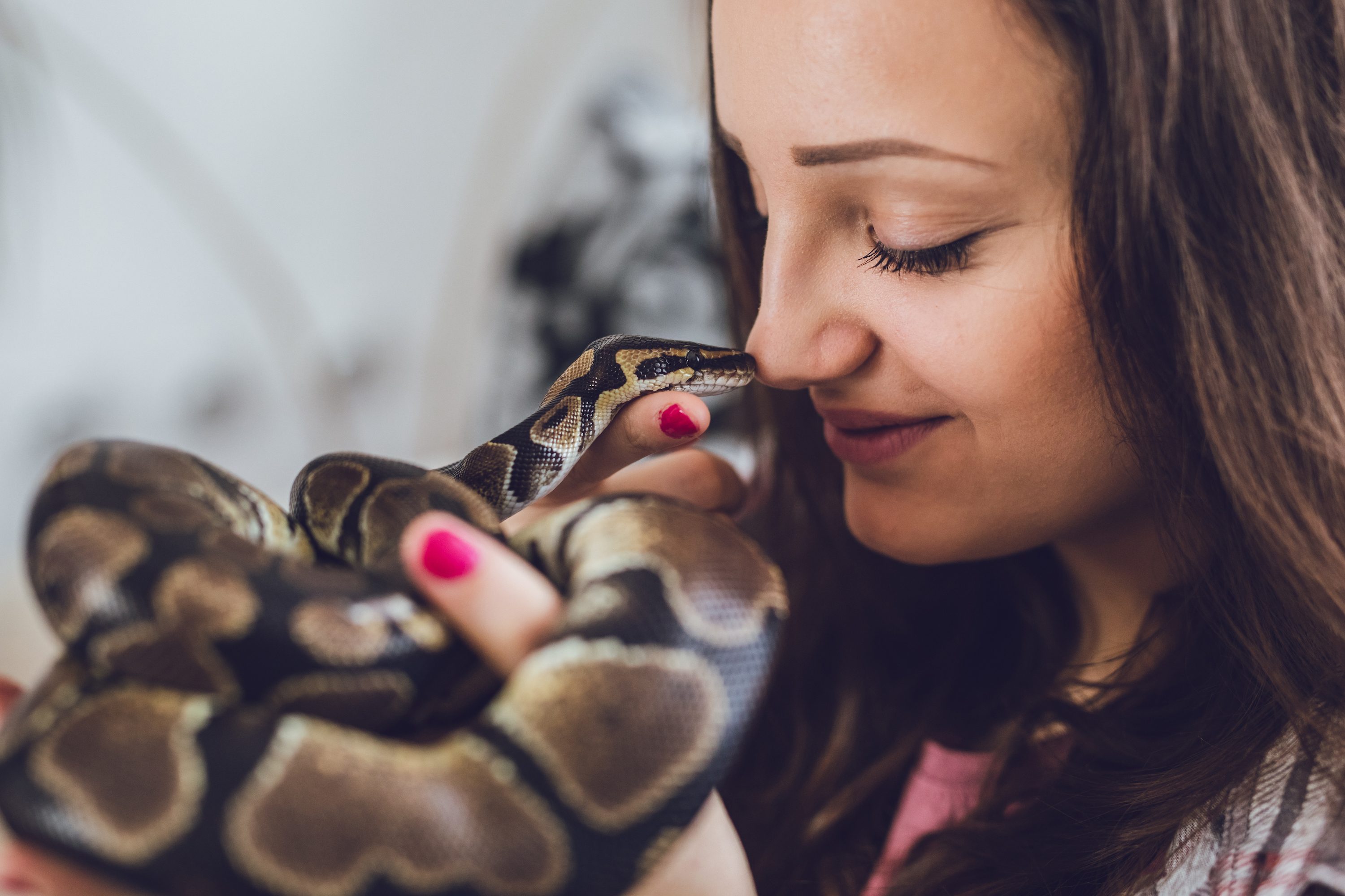 Woman holds her snake up to her face