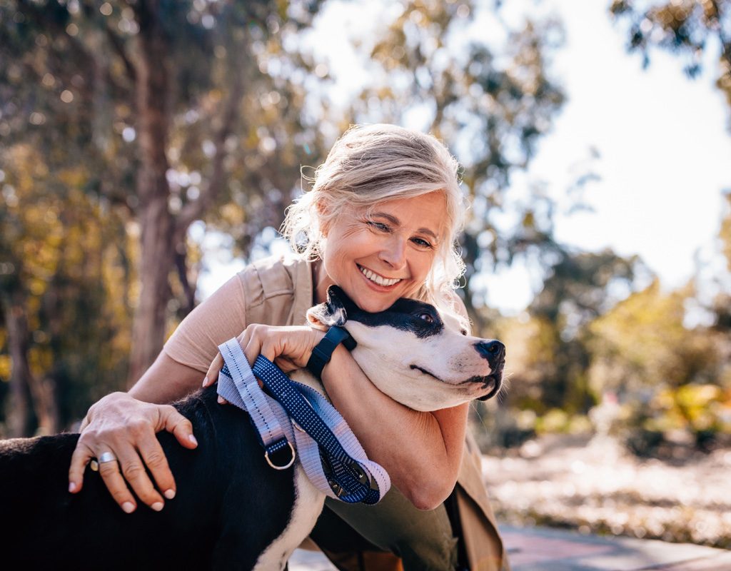 Woman hugging older dog.