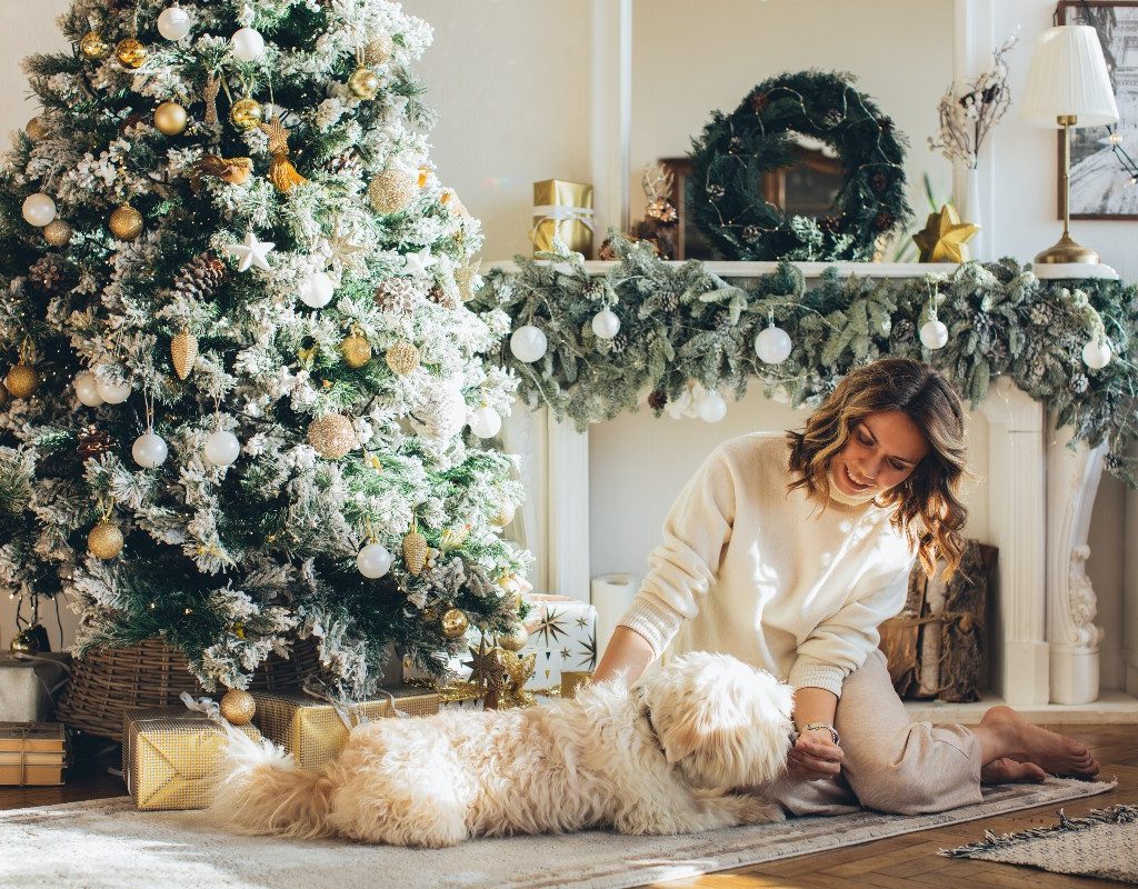 woman petting dog by tree