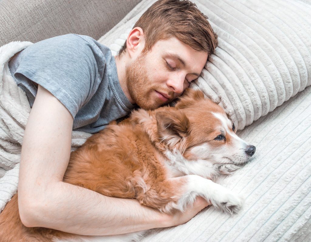 Man sleeping with his dog.