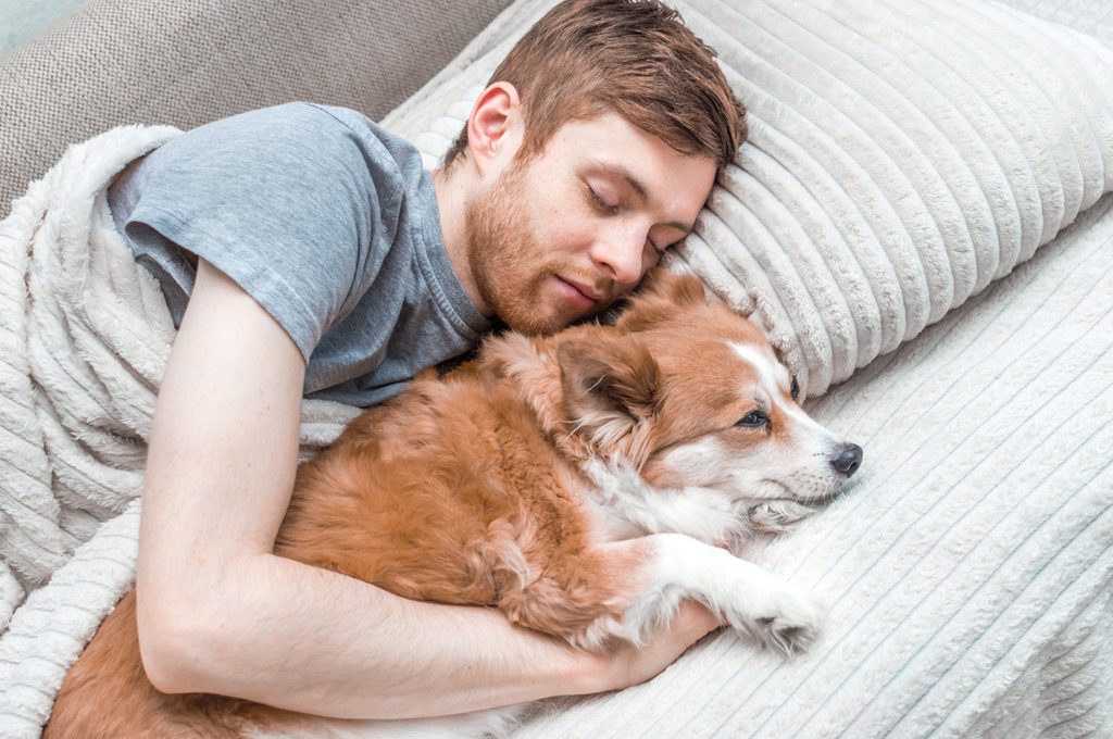 Man sleeping with his dog.