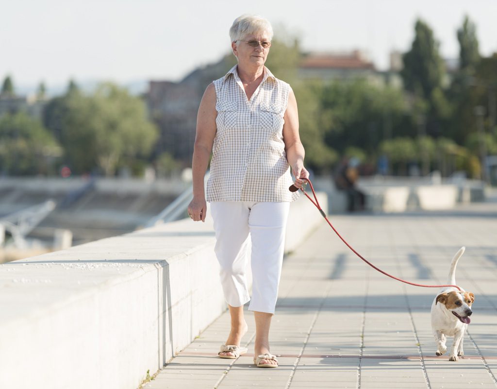 Senior woman walking her dog.