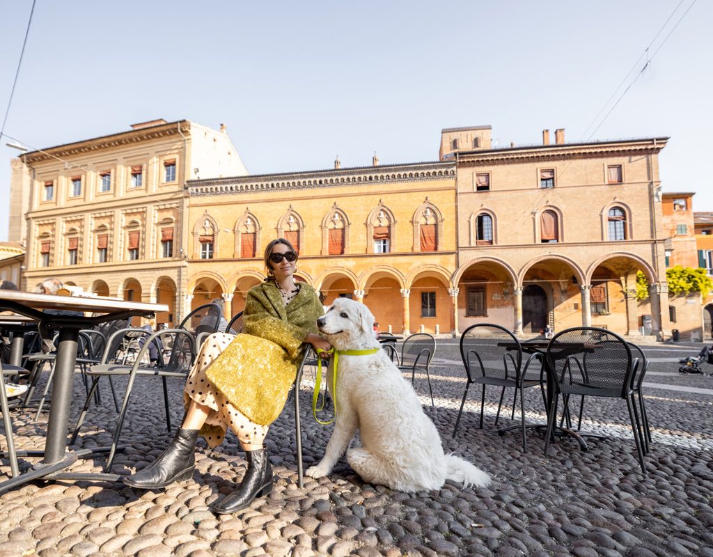Woman relaxing at an Italian restaurant with her dog.