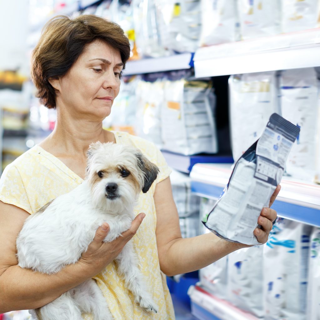 Woman shops for dog food with her dog