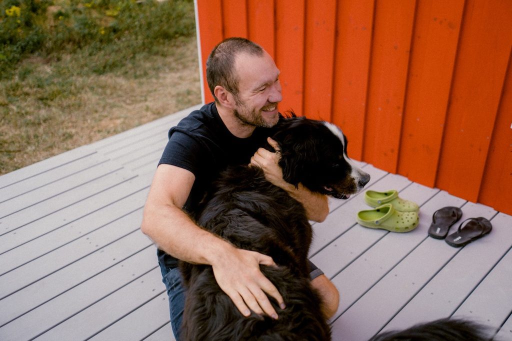 Man holds his Bernese mountain dog outside