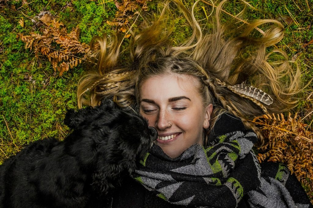 a black dog licking human's face