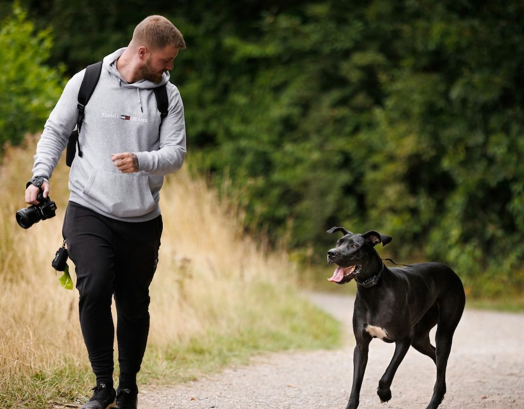 A dog walks next to his human outside