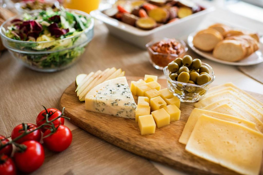 Cheese board on counter with other produce
