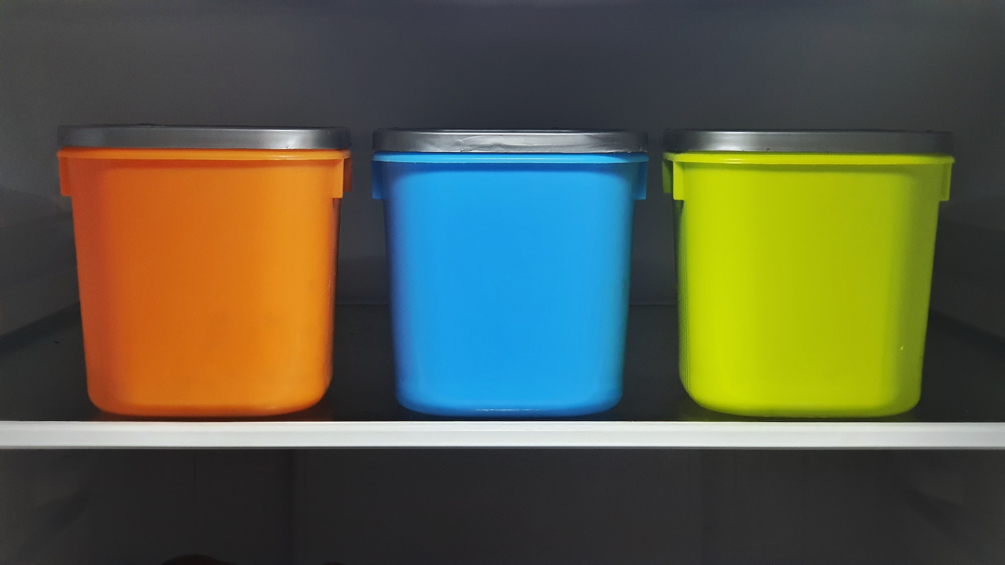 three colorful food storage containers