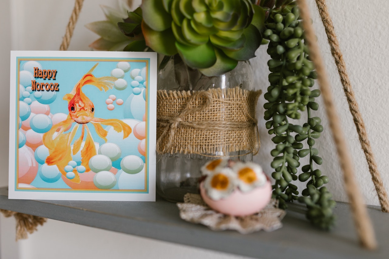 A goldfish portrait on a shelf.