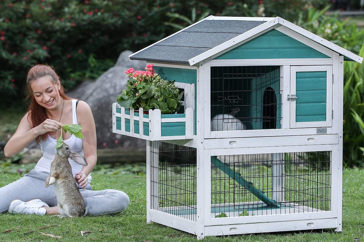 Woman plays with her rabbit next to the Petsfit Rabbit Hutch