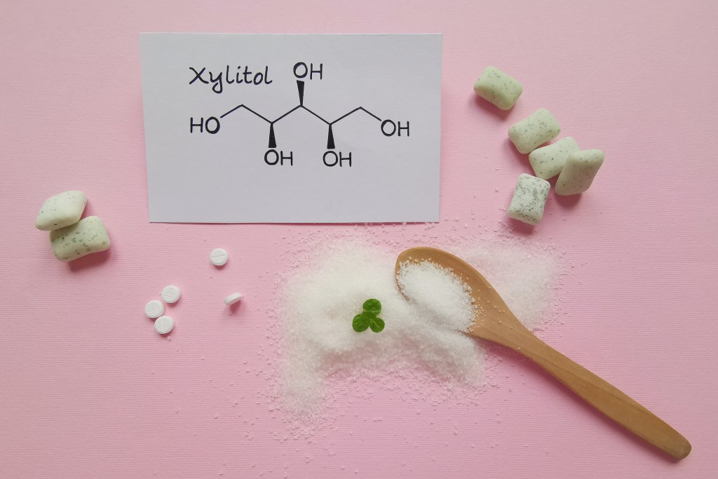 Xylitol with a wooden spoon and chemical structure