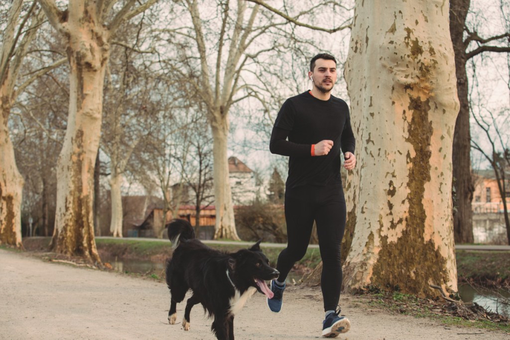 Vyras bėgioja su borderkoliu.