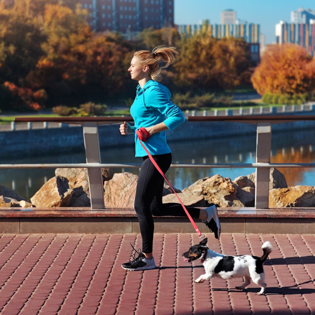 Woman running with terrier.