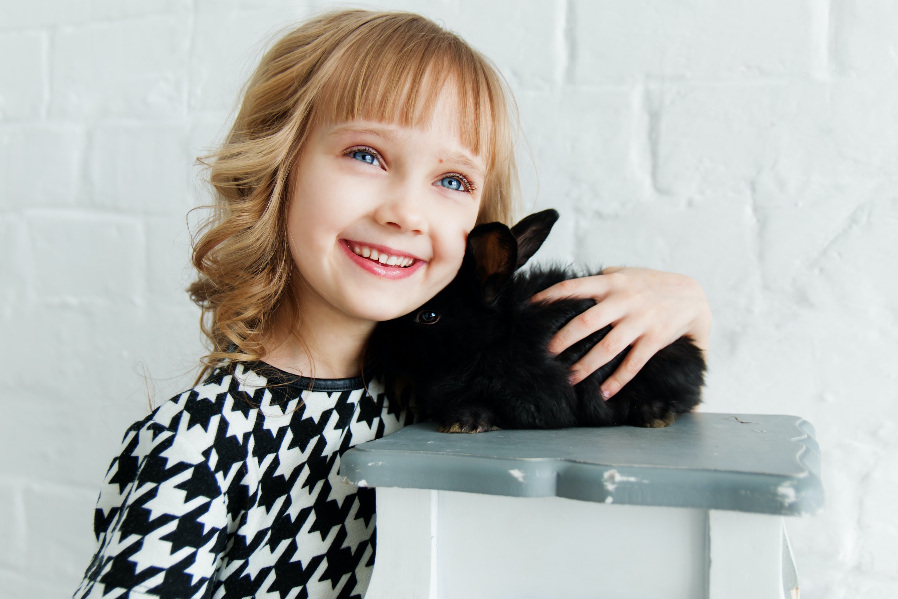 Girl hugs her pet black rabbit