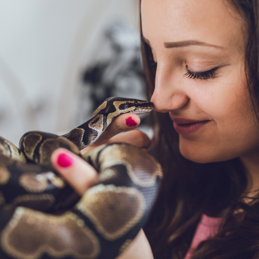 Woman holds her snake up to her face