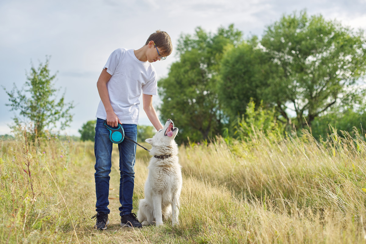 Teenage boy out on walk with dog.