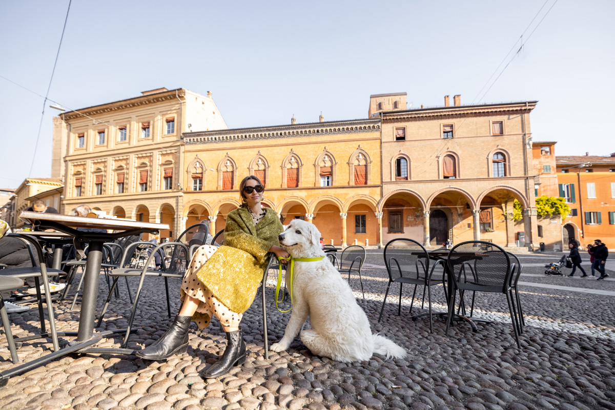Woman relaxing at an Italian restaurant with her dog.