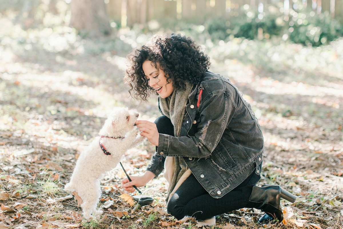 a woman treating a small puppy outside